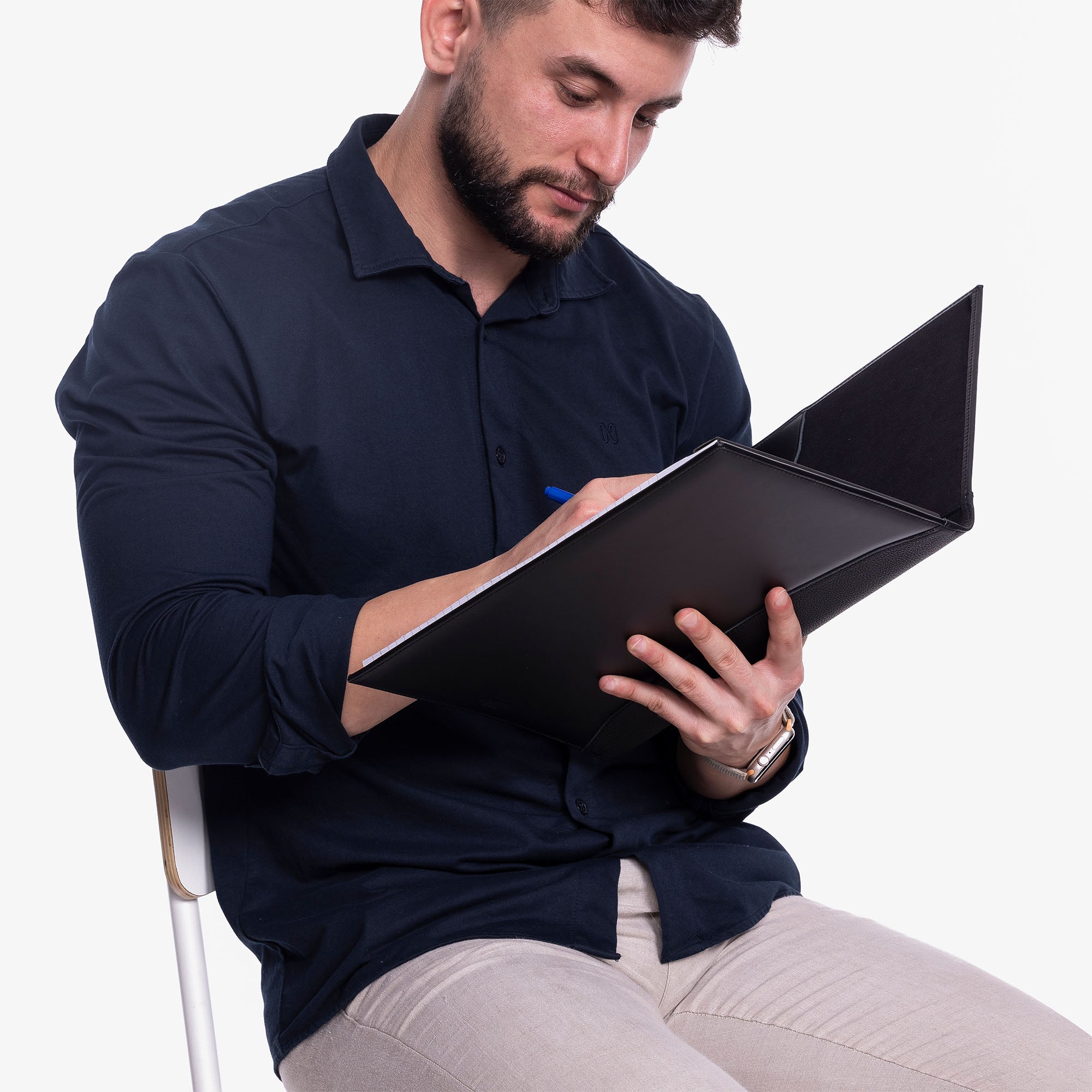 Black Leather A4 padfolio on the desk with model holding #color_black
