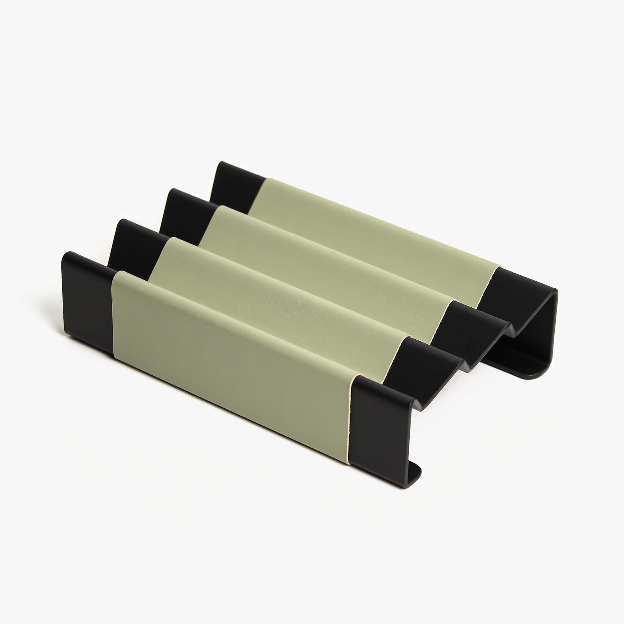 Top view of the sage-green leather and aluminum pen tray on a wooden desk