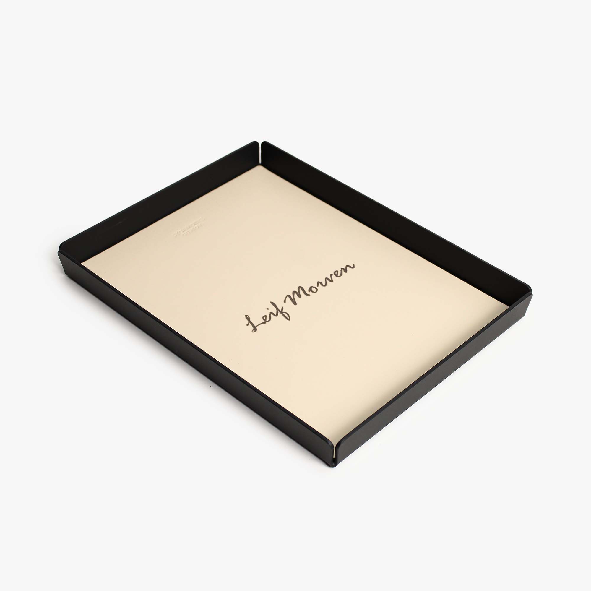 Top view of the beige leather and aluminum valet tray on a wooden desk