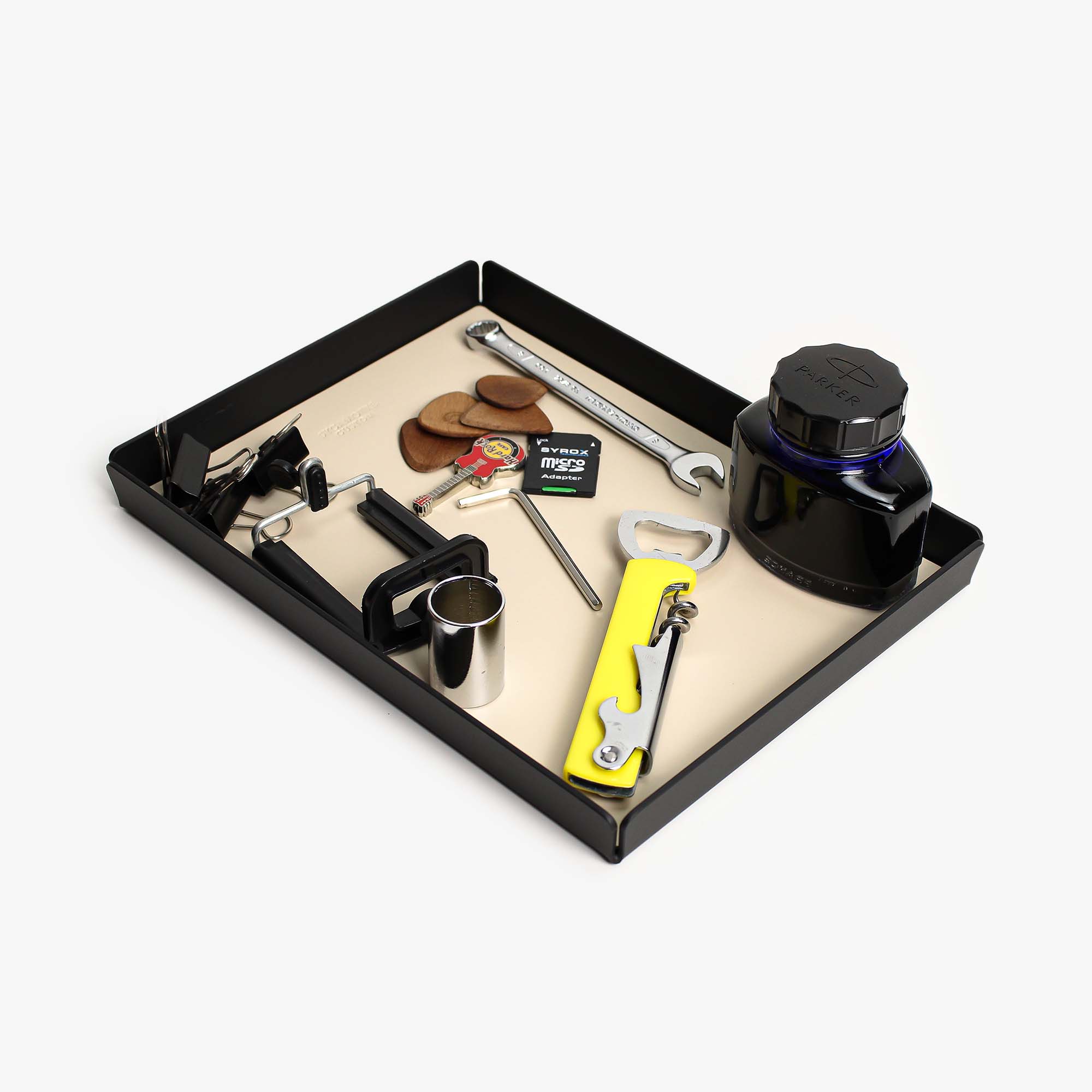 Top view of the beige leather and aluminum valet tray on a wooden desk