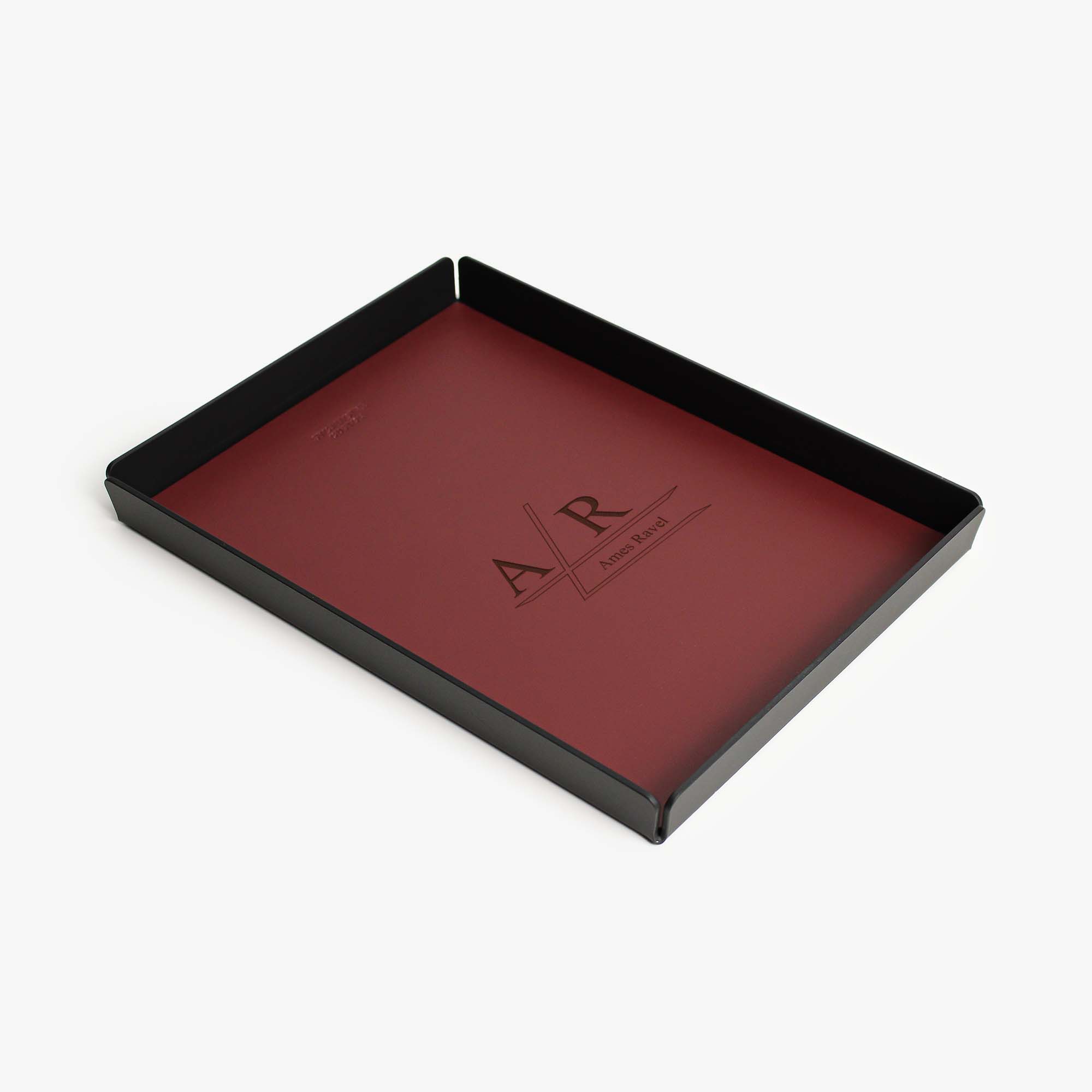 Top view of the burgundy leather and aluminum valet tray on a wooden desk