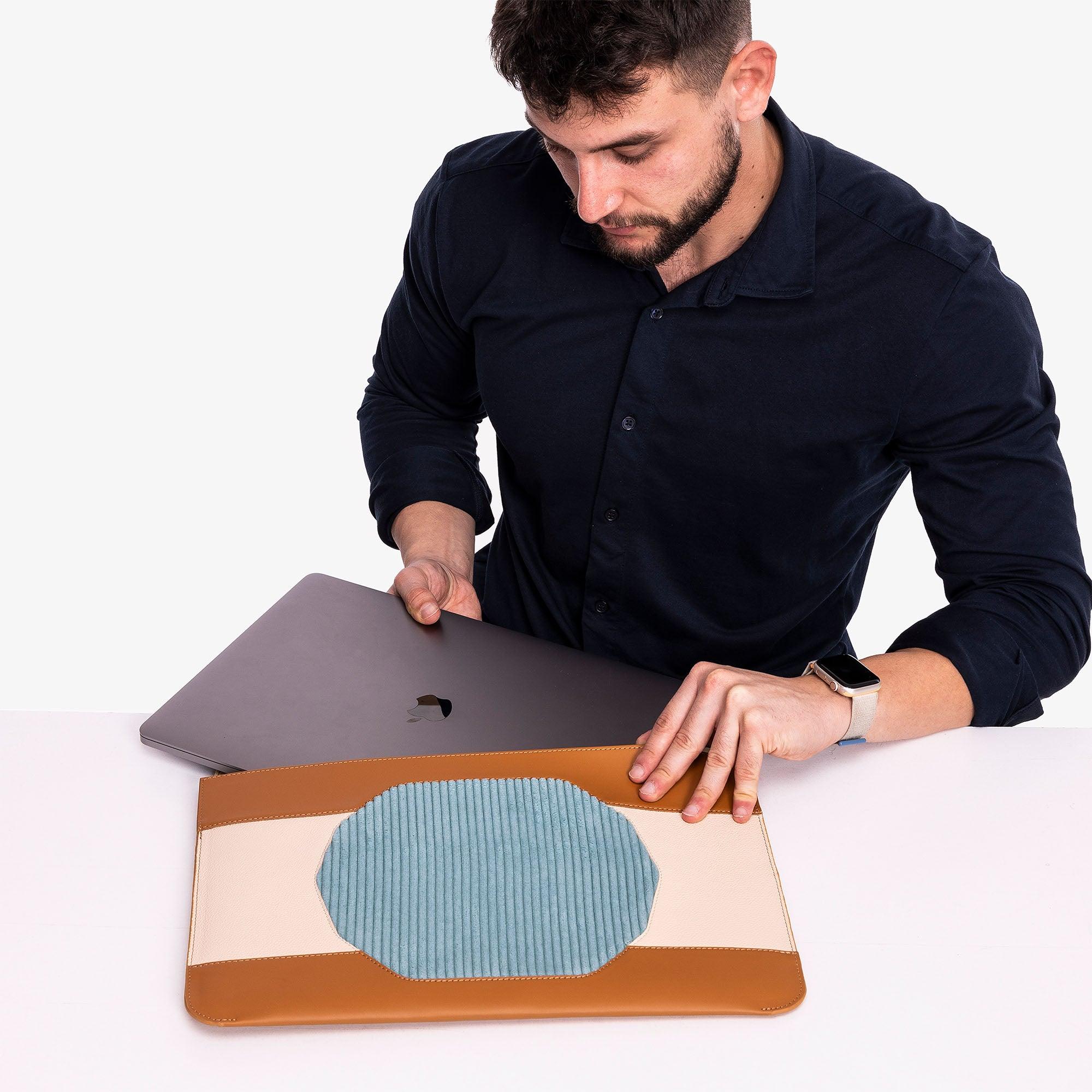 Model using Custom tan leather MacBook sleeve with personalization options