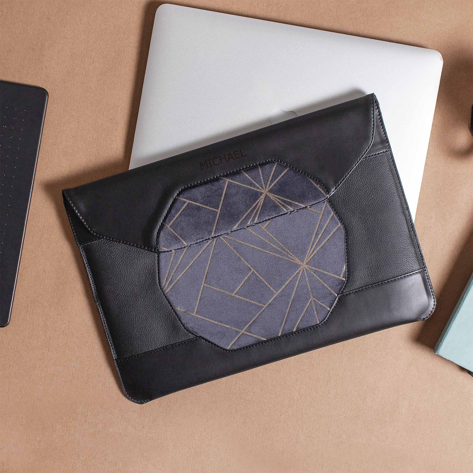 Personalized black leather MacBook sleeve on the desk