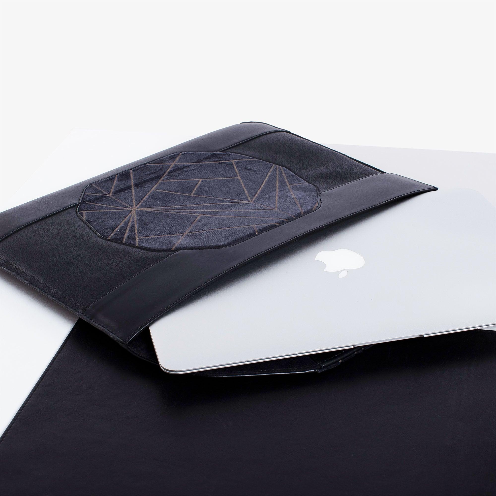 Personalized black leather MacBook sleeve on the desk