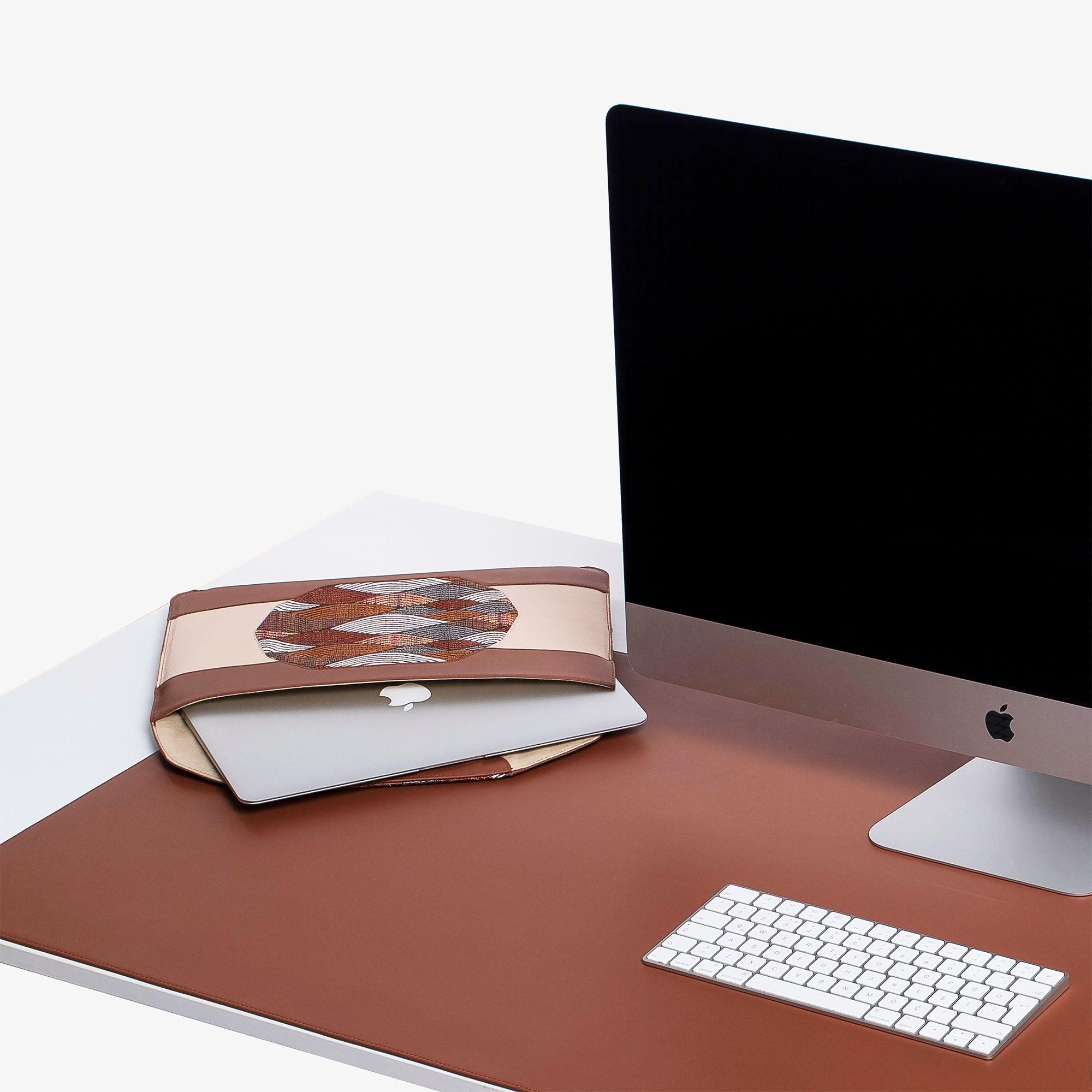 Custom brown leather MacBook sleeve on the desk