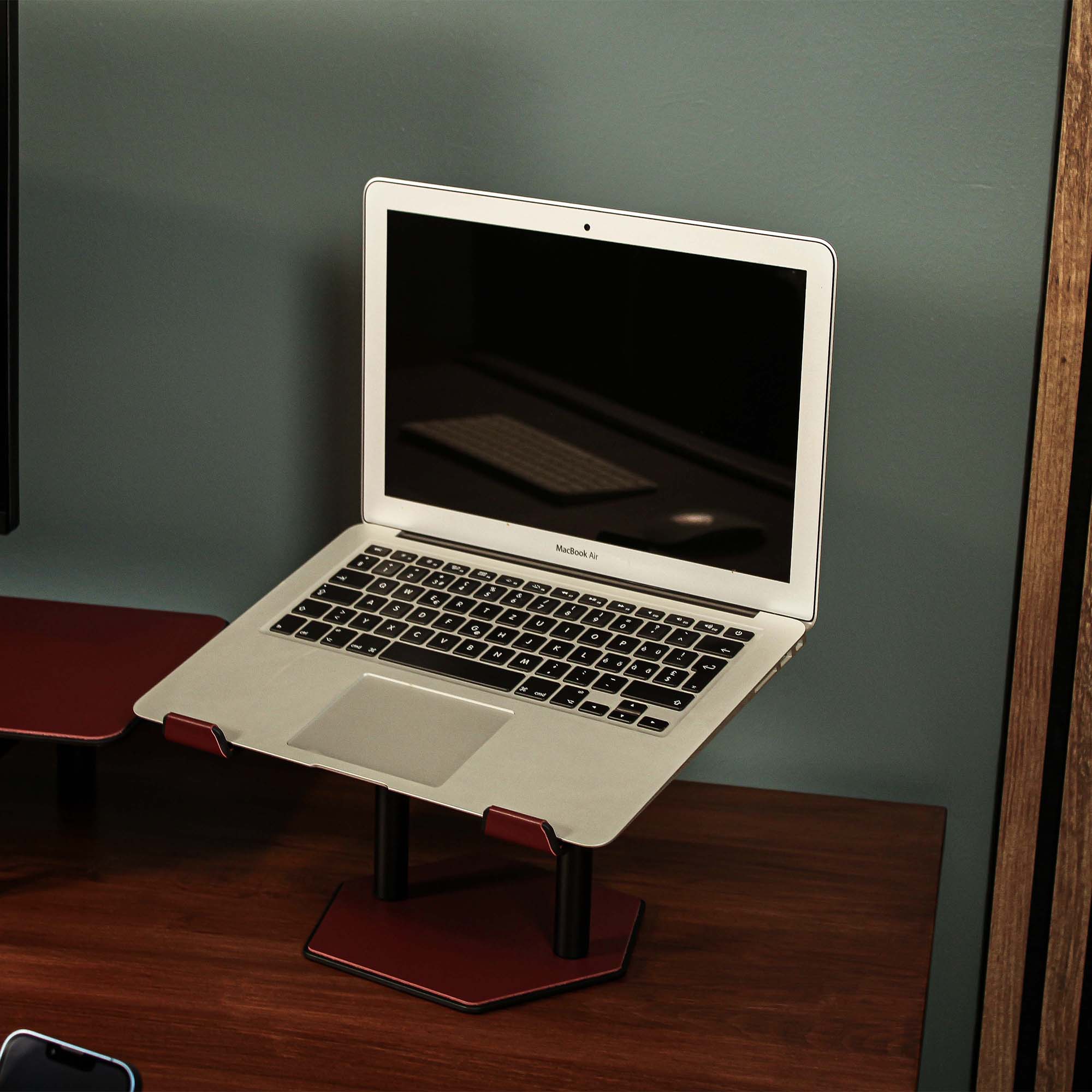 Lifestyle setup featuring the burgundy laptop riser with matching accessories