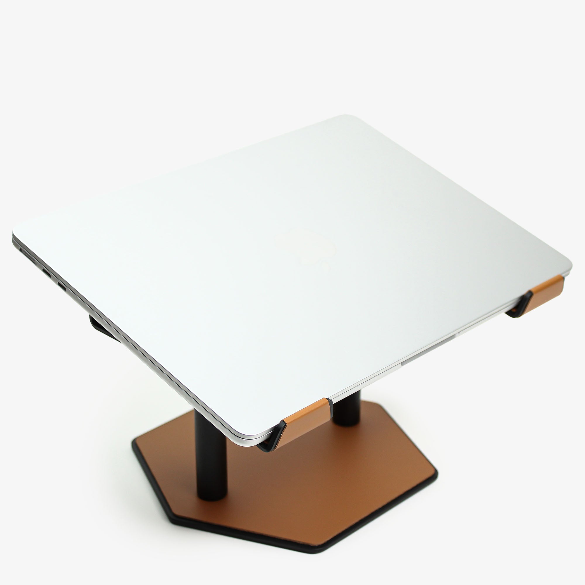 Side angle showing the ergonomic tilt of the cognac laptop stand