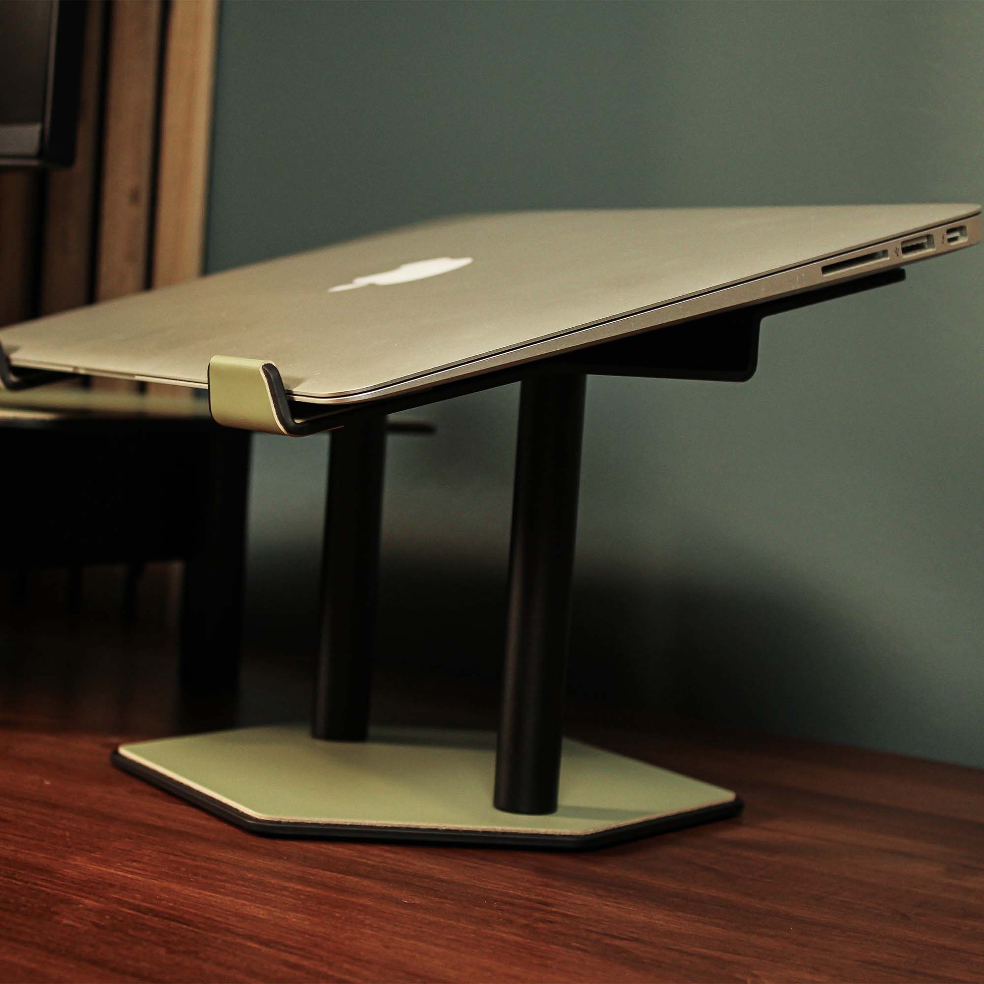 Side angle showing the ergonomic tilt of the sage-green laptop stand