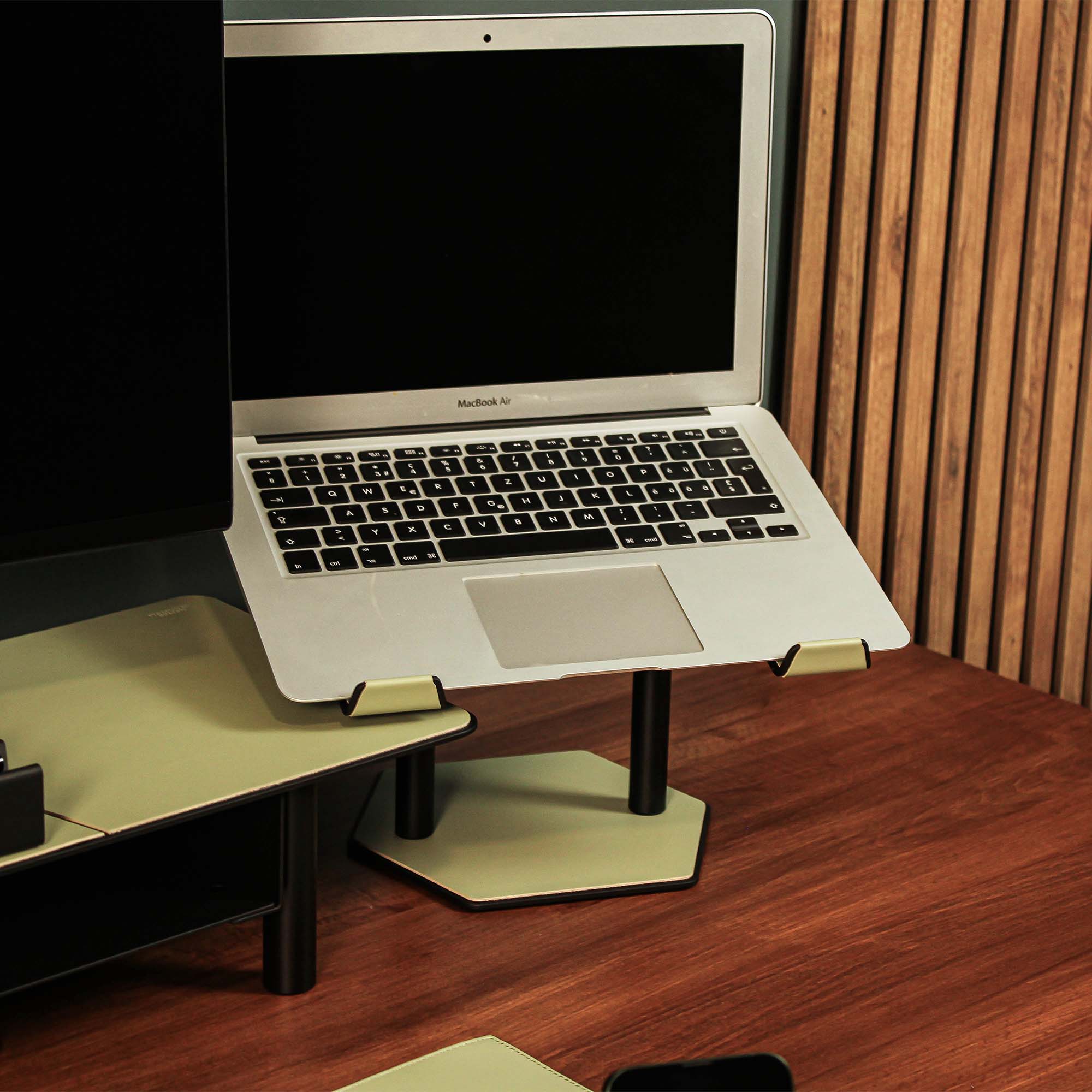 Lifestyle setup featuring the sage-green laptop riser with matching accessories