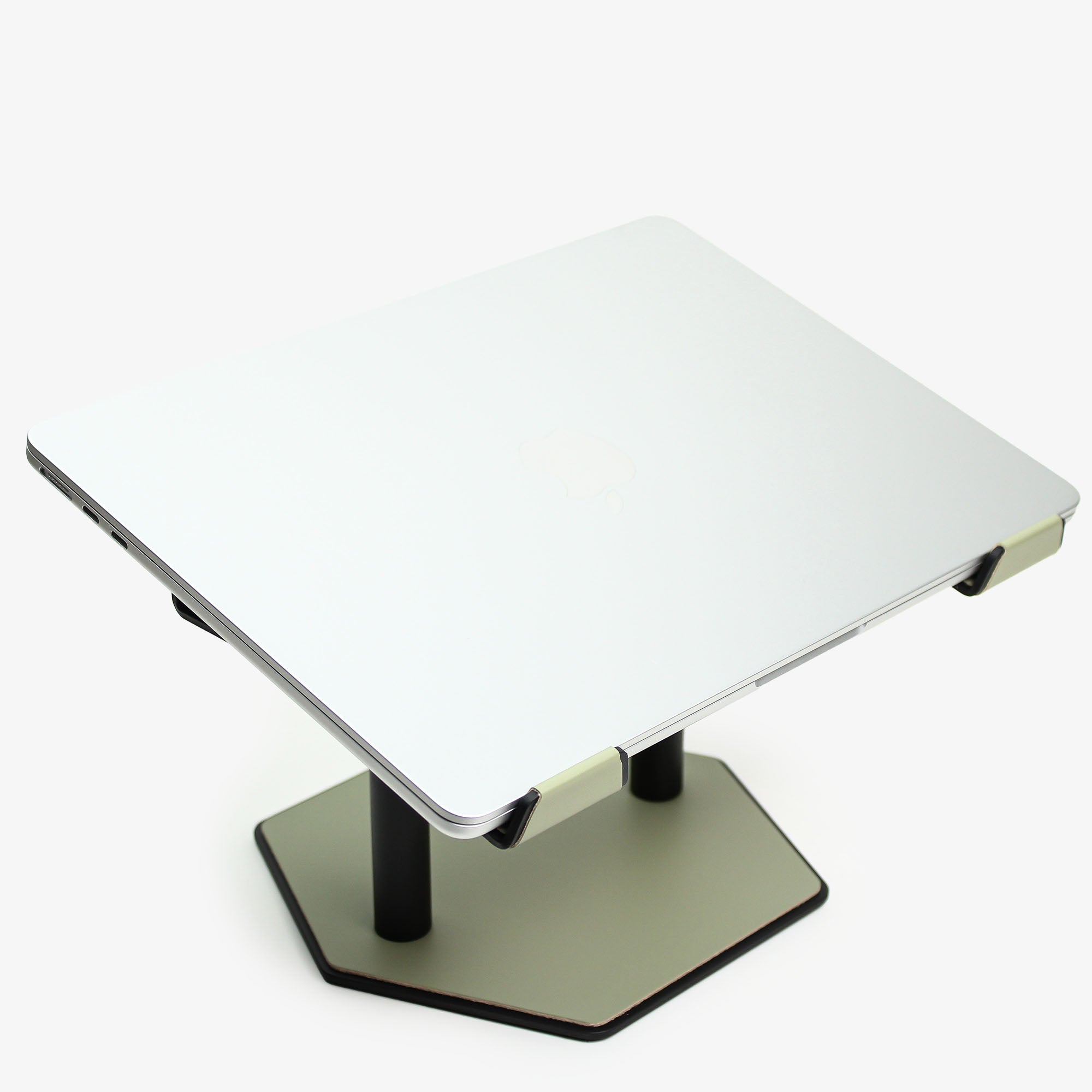 Top-down view of the sage-green laptop riser with smooth leather surface  with macbook