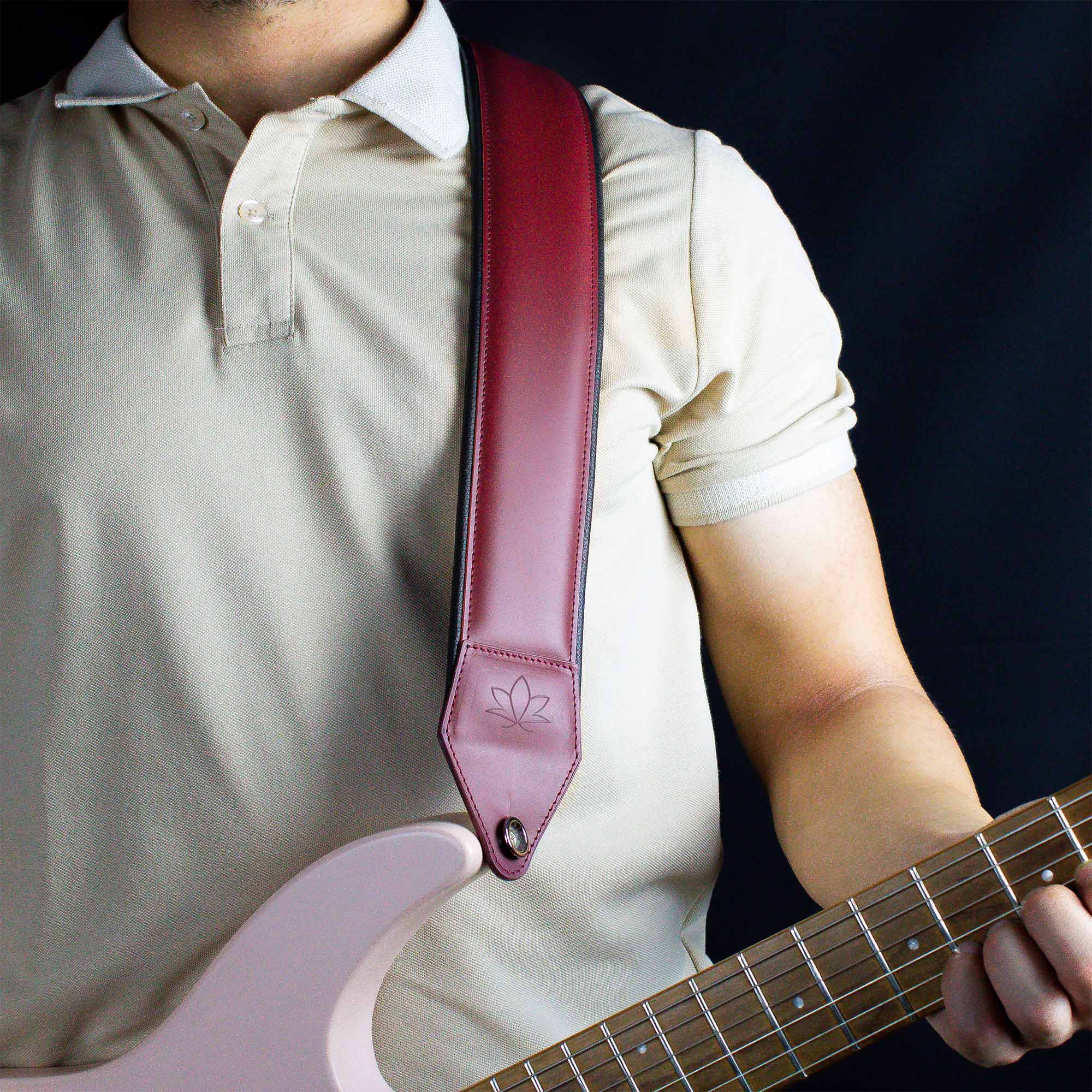 burgundy leather guitar strap attached to electric guitar