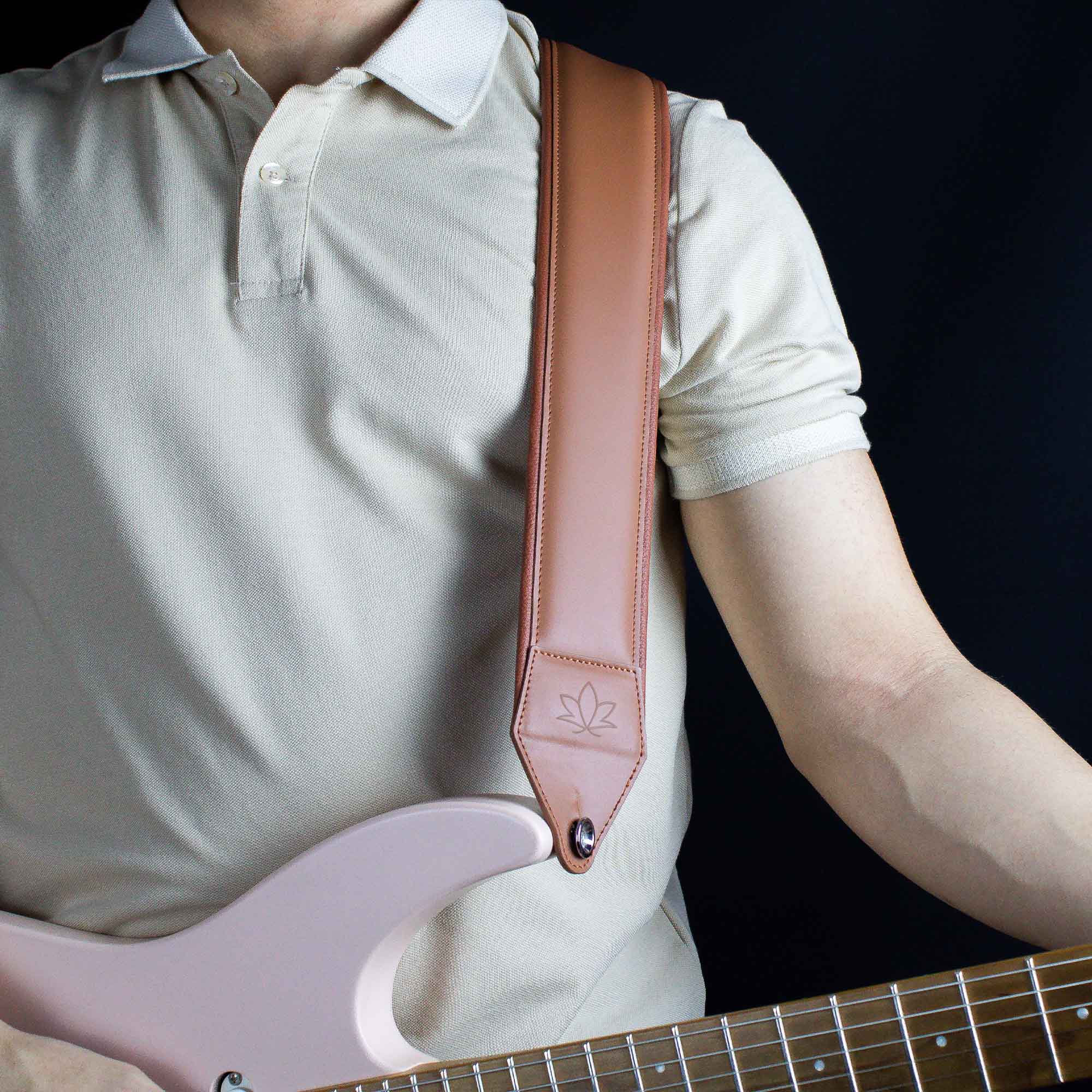 chesnut leather guitar strap attached to electric guitar