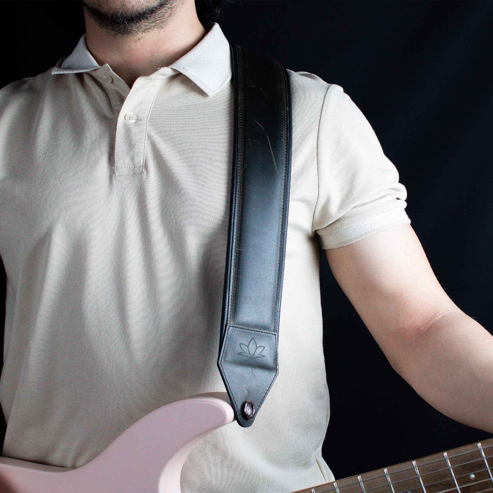 khaki leather guitar strap attached to electric guitar