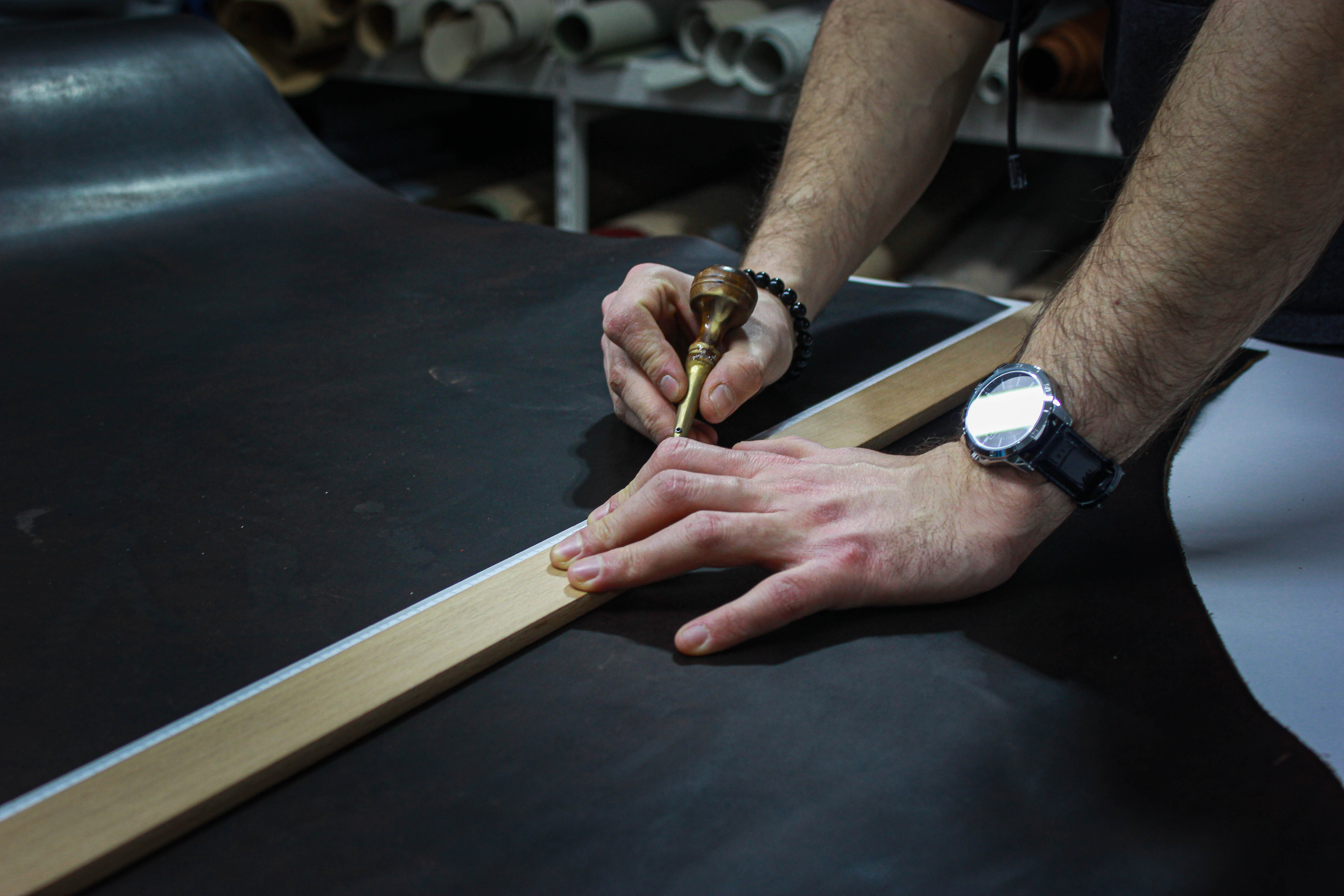 man cutting the leather